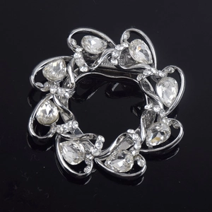 Elegant silver circular flower brooch with crystals and filigree petals on black background