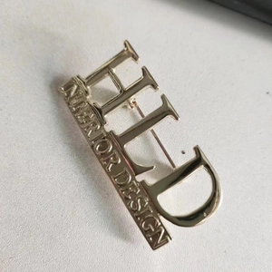 Elegant gold metal brooch with HLD Interior Design letter engraving for suit jackets