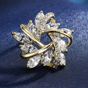 Close-up of a gold starburst brooch with marquise-cut and round clear cubic zirconia stones