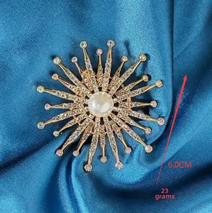 Détail d'une broche tournesol dorée de 6,0 cm avec strass blancs et perle centrale