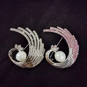 Elegant phoenix feather brooches with pink crystals, white pearls on black velvet