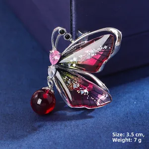 Macro shot of a butterfly brooch with pink zircons and silver metal frame detail