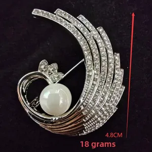 Detailed view of silver phoenix brooch with rhinestones and white pearl, 4.8cm height