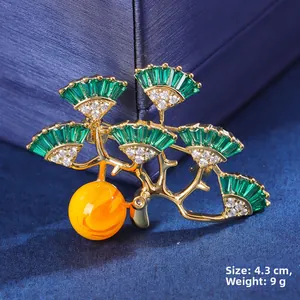 Detail of pine tree brooch with green zircon and amber-like bead measuring 4.3 cm