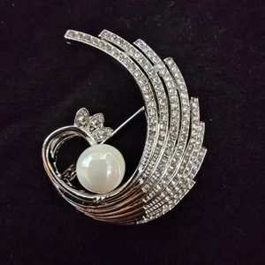 Close-up of elegant phoenix brooch featuring white rhinestones and a large round pearl
