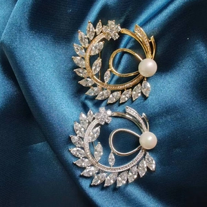 Detail of luxury gold and silver flower brooches with marquise zircons and pearls