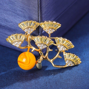 Elegant Chinese pine brooch with natural pearls and yellow crystals on blue jewelry box