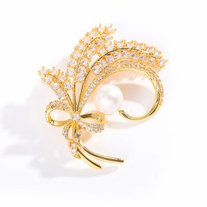 Elegant gold wheat brooch with sparkling zircons, white pearl, and bowknot detail