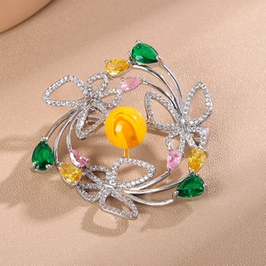 Broche couronne papillon élégante avec gemmes colorées et une perle jaune centrale