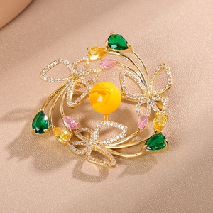 Détail de la broche couronne papillon dorée avec perles et pierres précieuses