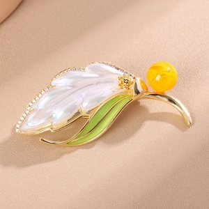 Elegant gold leaf brooch with white mother of pearl inlay and green zircon accents