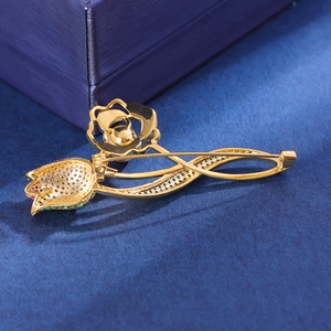 Broche tulipe élégante avec zircons verts et roses sur tissu texturé bleu marine
