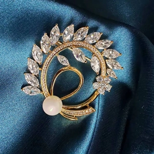 Elegant gold flower brooch with marquise cubic zirconia and a white pearl on silk