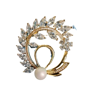 Elegant gold flower brooch with marquise zircons and white pearl on white background