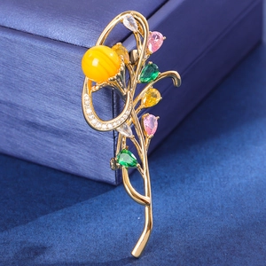 Macro shot of orchid brooch with pink and green gems on dark jewelry box