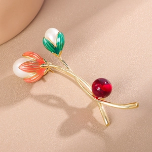 Nahaufnahme einer eleganten Tulpenbrosche mit grünem Emaille und Perlenverzierung