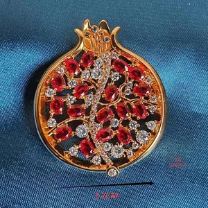 Makro-Detail der Granatapfel-Brosche mit roten Zirkonia-Steinen auf dunklem Stoff, 3,2cm
