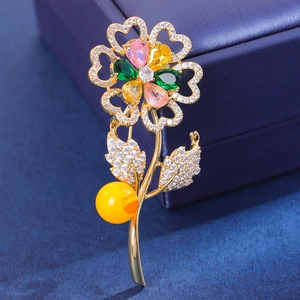 Luxury sunflower brooch with colorful gemstones and amber bead on a jewelry box