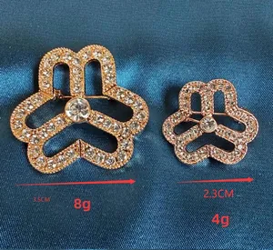 Detail view of rose gold floral brooches in two sizes with white crystal inlay