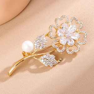 Detail of sunflower brooch with sparkling cubic zirconia, petals and a white pearl