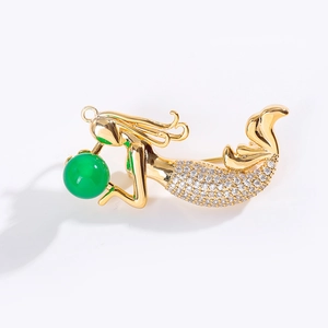 Élégante broche pendentif sirène dorée avec pierre verte et détails en cristaux blancs