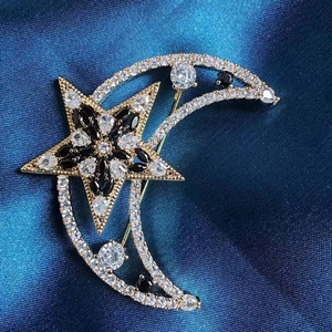 Vue macro d'une broche lune et étoile dorée avec cristaux de zircon blancs et noirs