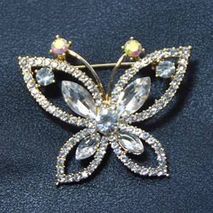 Vue détaillée d'une broche papillon dorée ornée de cristaux et de strass scintillants