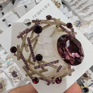 Gros plan d'une élégante broche en cristal violet avec base en alliage doré sur carte