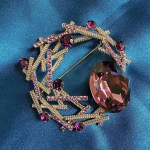 Vue détaillée de la broche anneau doré avec strass roses et cristaux violets fins