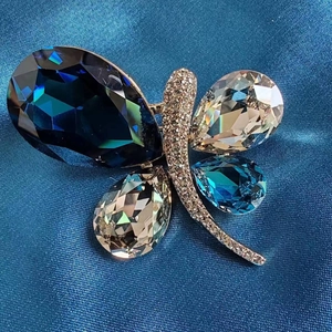 Macro detail of elegant butterfly brooch with faceted blue crystals and pavé rhinestones