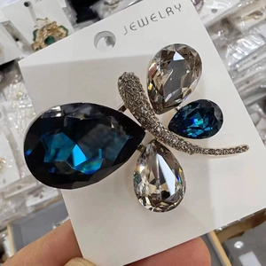 Elegant dragonfly brooch pin with blue and champagne crystals on a jewelry display card