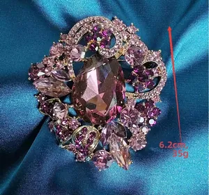 Detailed close-up of a luxury purple crystal floral brooch on blue silk fabric