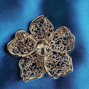 Champagne gold emerald crystal flower brooch with hollow patterns on blue satin