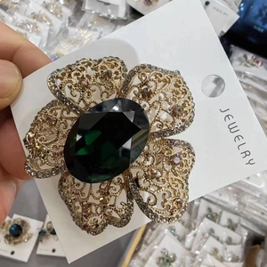 Elegant vintage flower brooch with emerald green stone and champagne crystals in gold finish