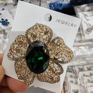 Vintage gold filigree flower brooch with large emerald green oval gemstone and crystals