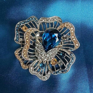 Elegant silver rose brooch with pear-shaped blue crystal and multi-color rhinestones