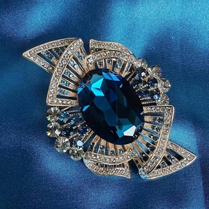 Vintage gold brooch with large sapphire blue crystal and sparkling white rhinestones