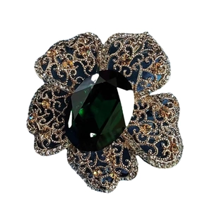Vintage floral brooch with deep green emerald-cut crystal and gold hollow petals