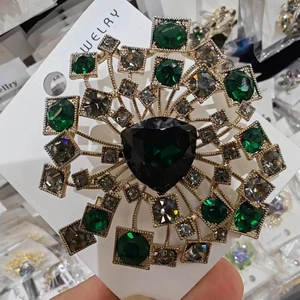 Spilla a dente di leone dorata con cristalli verde smeraldo e strass fumé lucidi