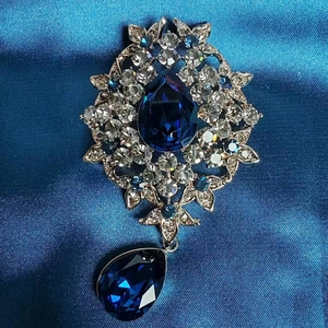 Broche argentée vintage avec cristal bleu poire et strass blancs scintillants