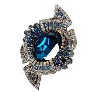 Vintage gold brooch with royal blue crystal and rhinestone geometric design on white