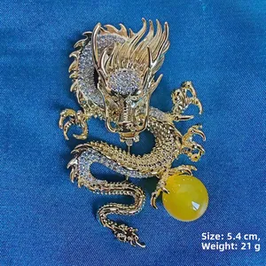 Detail view of gold dragon brooch with zircon inlay and amber bead, size 5.4cm and weight 21g