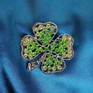 Élégante broche trèfle à quatre feuilles vert émeraude avec cristaux sur soie bleue