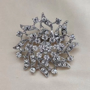 Elegant snowflake flower brooch with sparkling crystals on a silver metal base for women