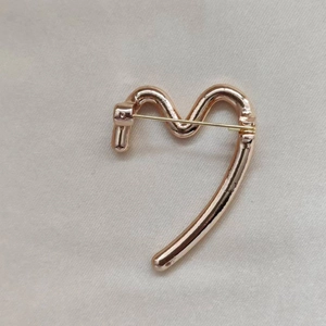 Minimalistische roségoldene unregelmäßige Wellenbrosche mit glatter Metalloberfläche