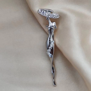 Broche élégante silhouette de femme argentée avec strass sur tissu en satin champagne