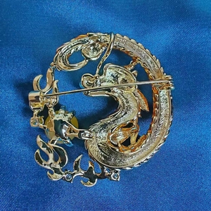 Golden dragon brooch with zircon inlay and blue accents, back view showing the pin buckle