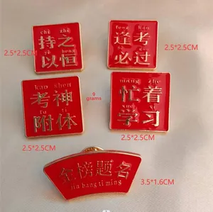 Detailed view of red enamel good luck brooches with golden motivational Chinese text