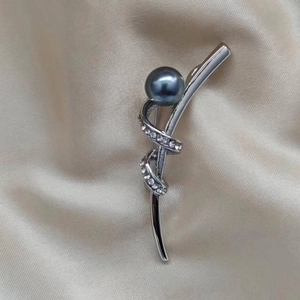 Elegante silberne Brosche in Schleifenform mit einer großen grauen Perle und Strasssteinen