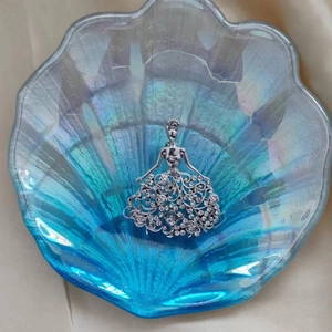 Detailansicht einer silbernen Engelsbrosche mit hohlem Blumendesign und weißen Kristallen